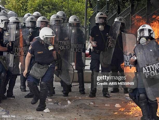 Molotov cocktails explodes behind Greek riot policemen during clashes in the center of Athens on May 5, 2010. Athens police chiefs mobilized all...