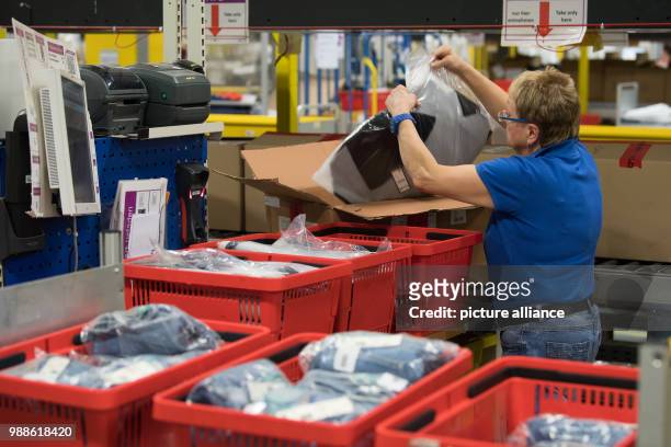 Employee Gabriele Blackert readies a mail order item for shipment during open media day of the electronic commerce giant Amazon, in Bad Hersfeld,...