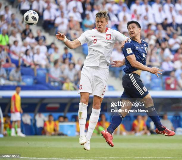 Japan's Shinji Okazaki heads at goal past Poland's Jan Bednarek at the first half of a World Cup Group H match in Volgograd, Russia, on June 28,...