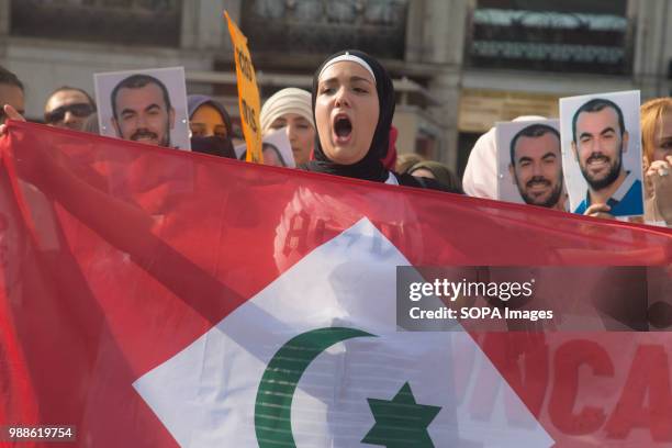 Woman holds a flag of the Rif while screaming against the repression in the Rif. Protest against a sentence of 20 years imprisonment to the rifan...