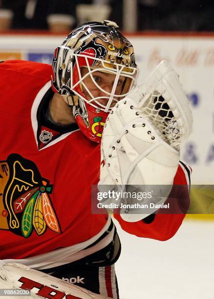 Antti Niemi of the Chicago Blackhawks looks at the puck in his glove after a save against the Vancouver Canucks in Game Two of the Western Conference...