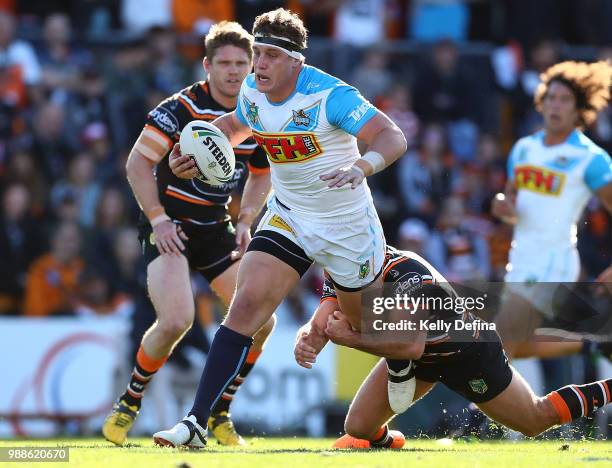 Jarrod Wallace of the Titans is tackled by Tigers defense during the round 16 NRL match between the Wests Tigers and the Gold Coast Titans at...