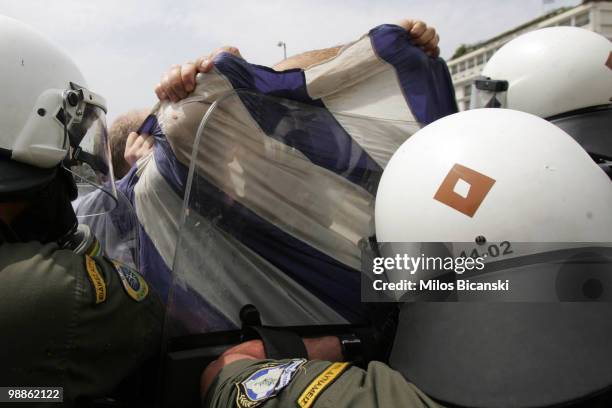 Protester is detained by Greek riot police outside parliament on May 5, 2010 in Athens, Greece. Three people have died after protesters set fire to...