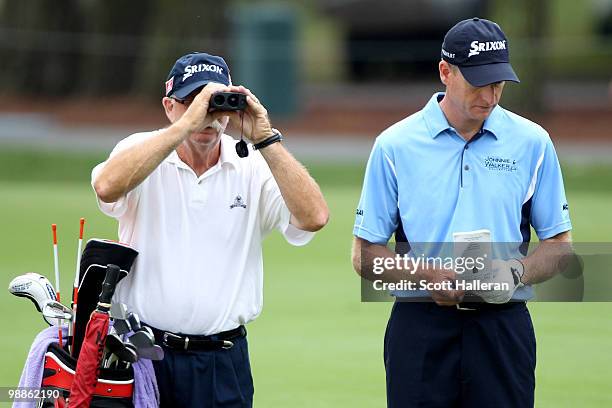 Caddie Mike "Fluff" Cowan uses binoculars alongside Jim Furyk during a practice round prior to the start of THE PLAYERS Championship held at THE...