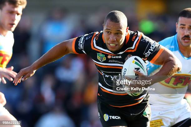Moses Mbye of the Tigers runs with the ball during the round 16 NRL match between the Wests Tigers and the Gold Coast Titans at Leichhardt Oval on...