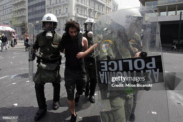 Protester is detained by Greek riot police outside parliament on May 5, 2010 in Athens, Greece. Three people have died after protesters set fire to...