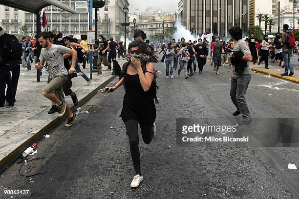 Protesters flee from tear gas deployed by Greek riot police as they clash on May 5, 2010 in Athens, Greece. Three people have died after protesters...