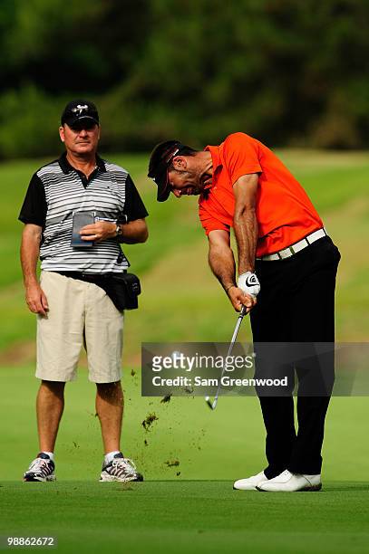 Caddie Alistair McLean looks on while Alvaro Quiros of Spain hits a shot during a practice round prior to the start of THE PLAYERS Championship held...