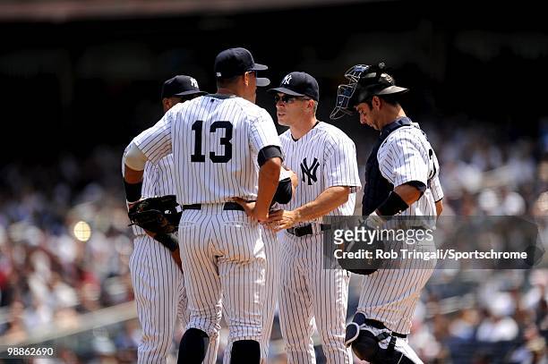 Joe Girardi manager of the New York Yankees tals to Javier Vazquez on the mound with Jorge Posada and Alex Rodriguez against the Chicago White Sox at...