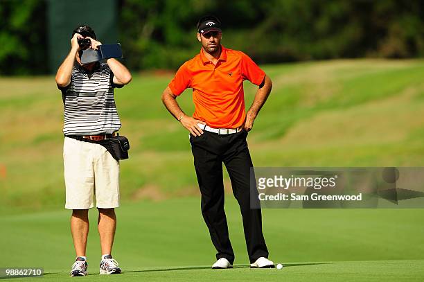 Alvaro Quiros of Spain and his caddie look on during a practice round prior to the start of THE PLAYERS Championship held at THE PLAYERS Stadium...