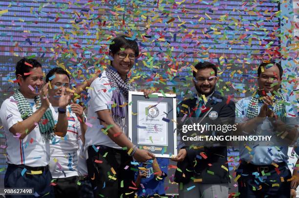 Swapnil Dangarikar , an adjudicator from the Guinness World Records, awards a certificate to Sann Vathana from the GoGo Cambodia movement, after a...