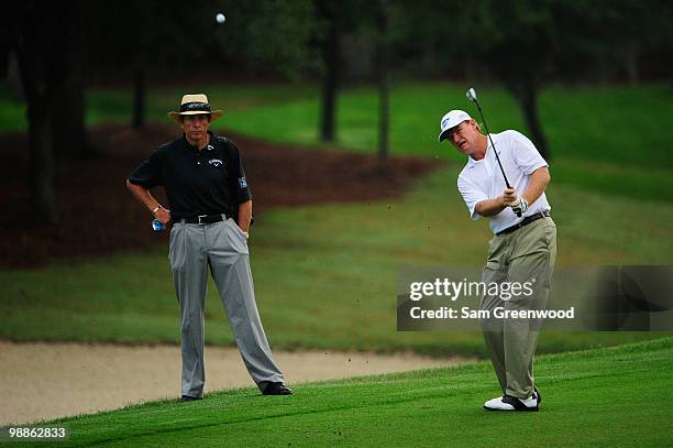 Ernie Els of South Africa plays a shot while golf instructor David Leadbetter looks on during a practice round prior to the start of THE PLAYERS...