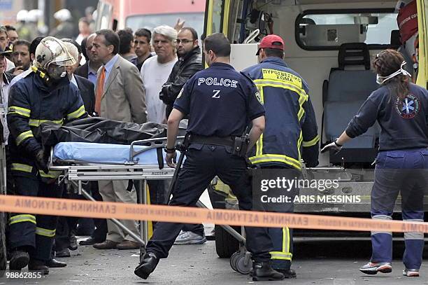 Firefighters carry the body of victim of a fire in a bank after a violent demonstration in the center of Athens on May 5, 2010. A nationwide general...