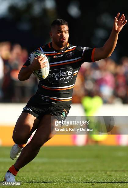 Esan Marsters of the Tigers runs with the ball during the round 16 NRL match between the Wests Tigers and the Gold Coast Titans at Leichhardt Oval on...