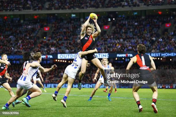 Dyson Heppell of the Bombers gathers the ball from Jy Simkin of the Kangaroos during the round 15 AFL match between the Essendon Bombers and the...