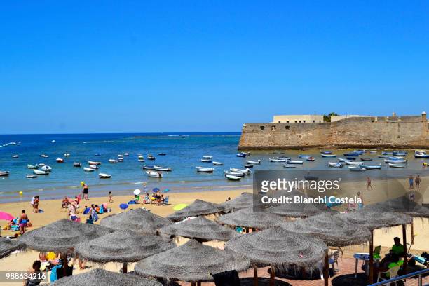 tourists on the beach of la caleta in cadiz, spain - playa de la caleta stock pictures, royalty-free photos & images