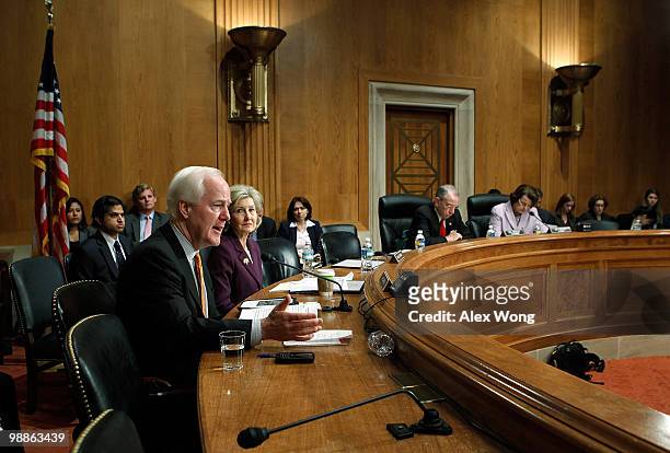 Sen. John Cornyn speaks as Sen. Kay Bailey Hutchison listens during a hearing before the Senate Caucus on International Narcotics Control May 5, 2010...