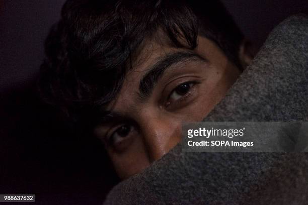Refugee uses a UNHCR blanket to stay warm during a cold Serbian winter. The Barracks in Belgrade were abandoned buildings behind the central train...