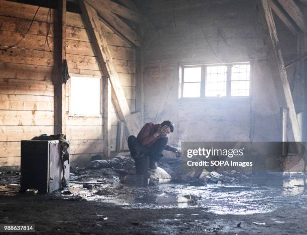 An Afghan refugee washes himself using warm water and soap as steam evaporates off his body during a cold winter in the Barracks. The Barracks in...