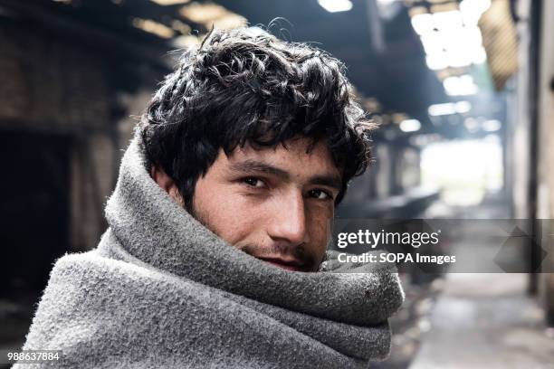 Refugee uses a UNHCR blanket to stay warm during a cold Serbian winter. The Barracks in Belgrade were abandoned buildings behind the central train...