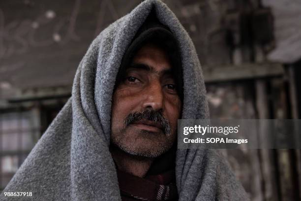 Migrant from Pakistan uses a UNHCR blanket to stay warm during a cold Serbian winter. The Barracks in Belgrade were abandoned buildings behind the...