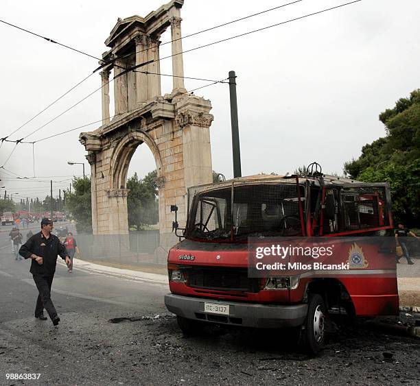 Burnt out fire fighting vehicle is backdropped by the ancient Adrianu gate after protesters clashed with Greek riot police on May 5, 2010 in Athens,...