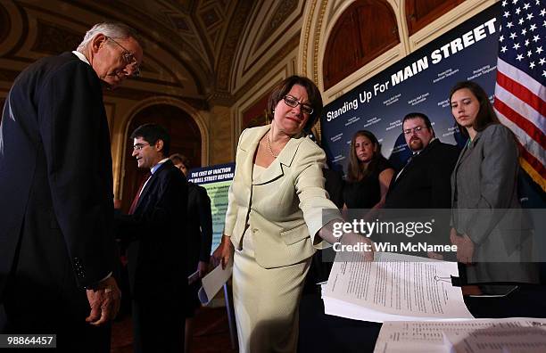 Senate Majority Leader Harry Reid watches as Sen. Amy Klobuchar picks up a stack of petitions from U.S. Citizens asking for financial industry reform...