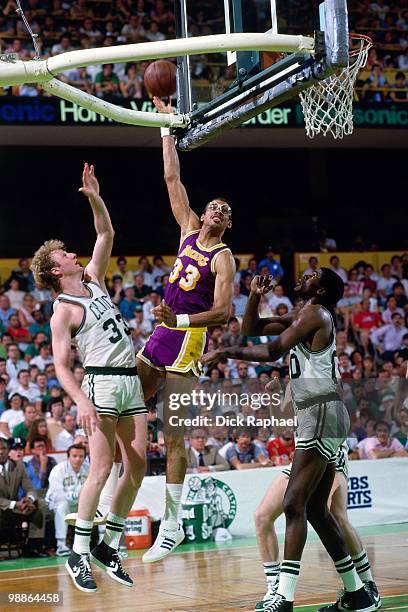 Kareem Abdul-Jabbar of the Los Angeles Lakers shoots a hook shot against Larry Bird and Robert Parish of the Boston Celtics during the 1985 NBA...