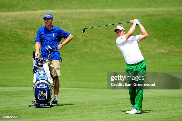 Luke Donald of England hits a shot while caddie John McLaren looks on during a practice round prior to the start of THE PLAYERS Championship held at...