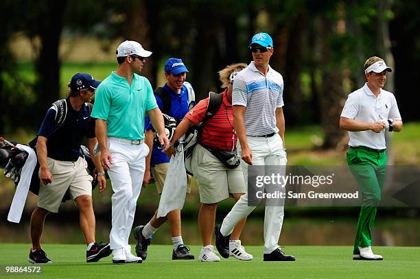 Paul Casey of England, Henrik Stenson of Sweden and Luke Donald of England walk with their caddies during a practice round prior to the start of THE...