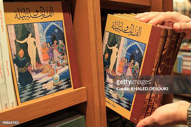 An Egyptian employee puts copies of "One Thousand and One Nights," known in English as "Arabian Nights," on a shelf at a bookstore in Cairo on May 5,...
