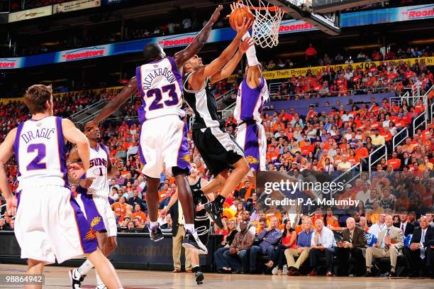 Tony Parker of the San Antonio Spurs lays the ball up against Jason Richardson and Leandro Barbosa of the Phoenix Suns in Game One of the Western...