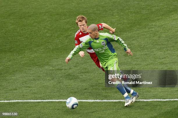 Midfielder Osvaldo Alonso of the Seattle Sounders dribbles the ball against Dax McCarty of FC Dallas at Pizza Hut Park on April 22, 2010 in Frisco,...