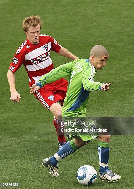 Midfielder Osvaldo Alonso of the Seattle Sounders dribbles the ball against Dax McCarty of FC Dallas at Pizza Hut Park on April 22, 2010 in Frisco,...
