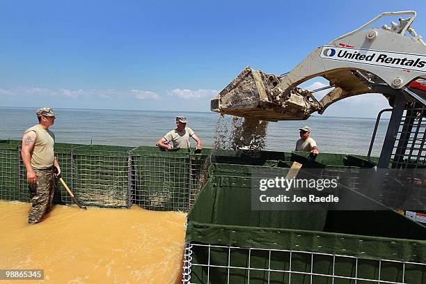 Alabama National Guard members Sergeant Bernard Blaize Sergeant 1st Class Shelton Lowery and Sergeant Troy Fitzhugh work on erecting a HESCO...