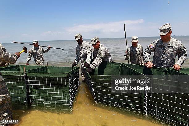 Alabama National Guard members erect a HESCO container barrier in an effort to protect the coast line from the massive oil spill in the Gulf of...