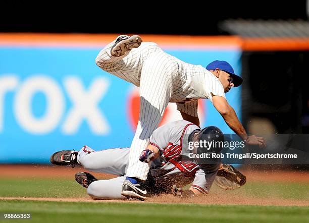 Alex Cora of the New York Mets attempts to complete a double play as Matt Diaz of the Atlanta Braves slides into him on April 24, 2010 at Citi Field...