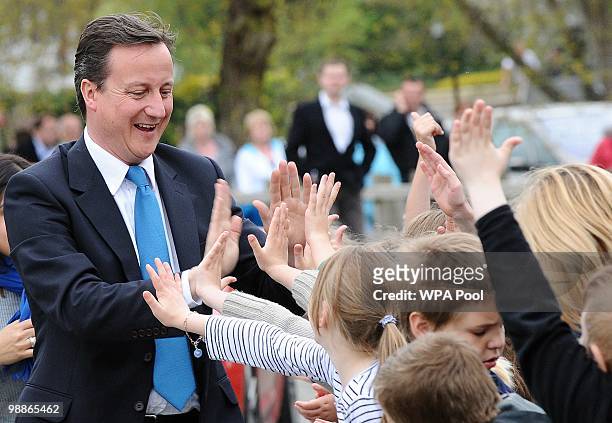 British opposition Conservative party Leader David Cameron gestures as he talks to pupils during an election campaign visit to Ysgol Dafydd Llwyd...