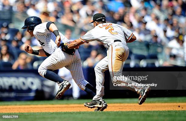 Francisco Cervelli of the New York Yankees is caught in a rundown by Julio Lugo of the Baltimore Orioles at Yankee Stadium on May 5, 2010 in the...