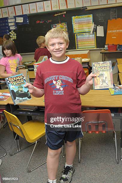 Harry S. Truman student shows off his signed copies of Frankie Pickle books by author Eric Wight at the donation of $1000 in OfficeMax Supplies to...