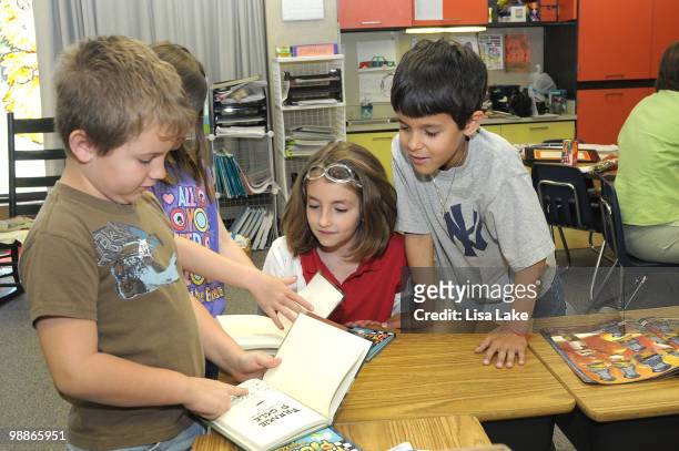 Harry S. Truman student looks at his signed copy of Frankie Pickle book by author Eric Wight at the donation of $1000 in OfficeMax Supplies to...