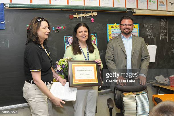 Office Max representative Mariann Worsinger and author Eric Wight surprise elementary school teacher Ms. Mary Beth Bedics with a donation of $1000 in...