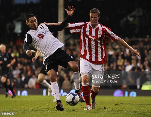 Clint Dempsey of Fulham battles with Robert Huth of Stoke City during the Barclays Premier League match between Fulham and Stoke City at Craven...