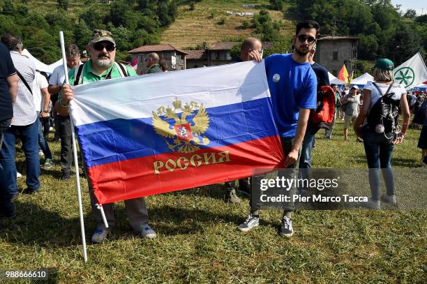 Two supporters of the Northern League pose with a Russian Federation flag at the Lega Nord Meeting on July 1, 2018 in Pontida, Bergamo, Italy.The...