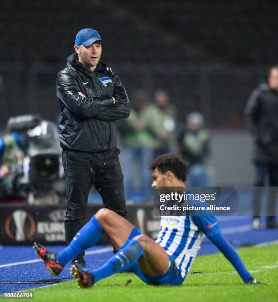 Berlin's head coach Pal Dardai watches on while player Valentino Lazaro sits on the ground during the Europa League group J soccer match between...