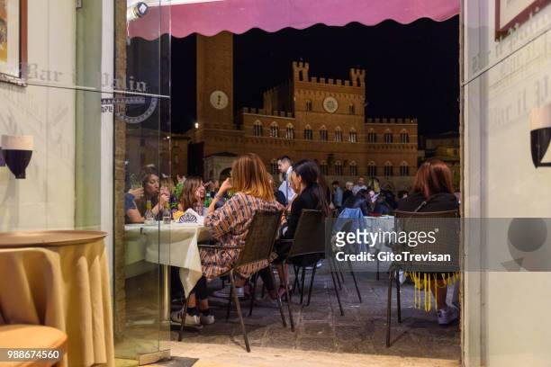 siena - saturday nightlife in piazza del campo - moving down to seated position stock pictures, royalty-free photos & images