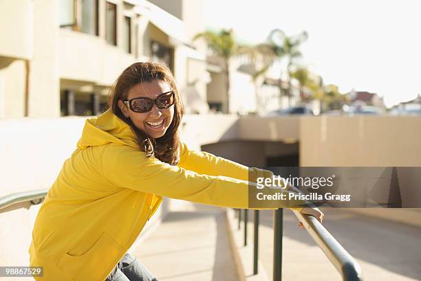 mixed race woman in sunglasses leaning on railing - coronado island stock pictures, royalty-free photos & images