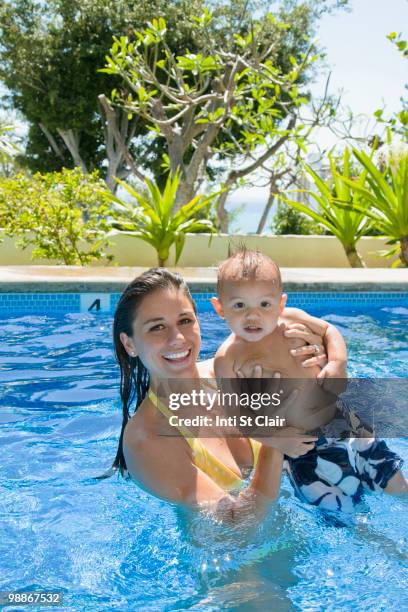 mother playing with son in swimming pool - inti st clair stock pictures, royalty-free photos & images