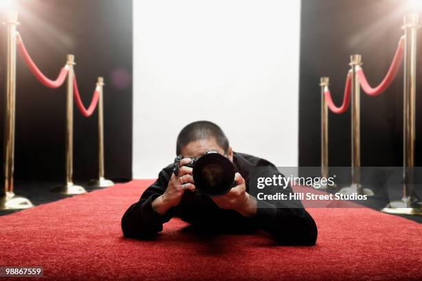 chinese photographer laying on red carpet - red carpet paparazzi stock pictures, royalty-free photos & images