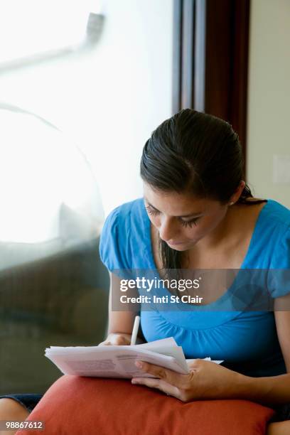 mixed race woman filling out forms - inti st clair stock pictures, royalty-free photos & images